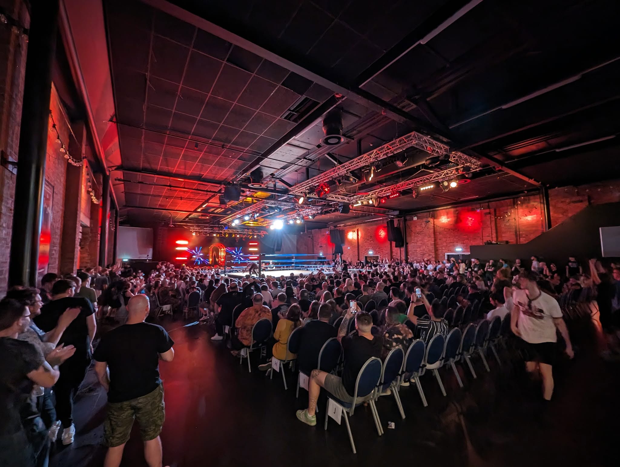 Crowd and stage under red lighting at a live event
